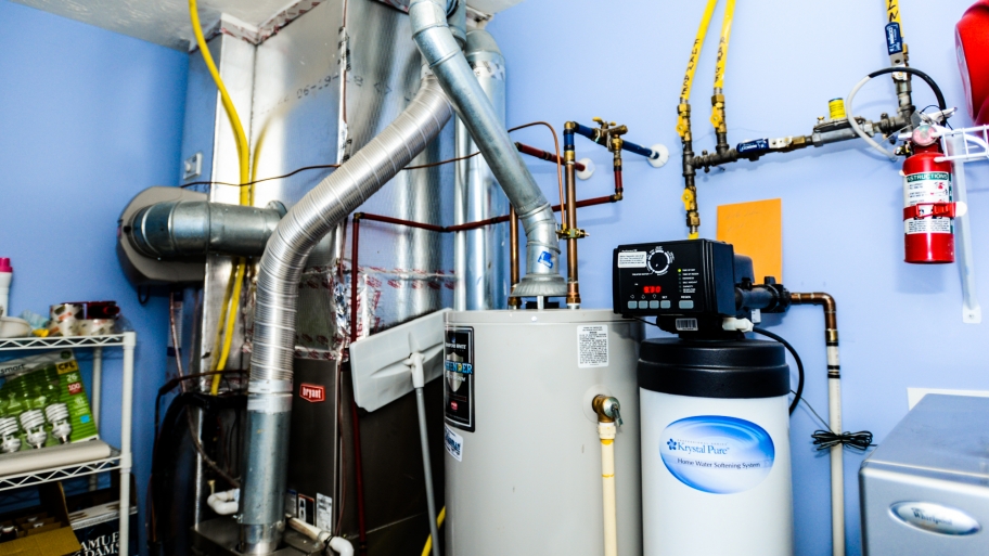 A water softener sits next to several other appliances in a utility room.